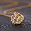 A gold-toned cross charm necklace with a textured surface is displayed on a dark background.