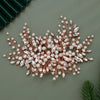 A delicate bridal headpiece made of rose gold wire adorned with pearls and clear rhinestones.