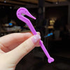 A hand holds a purple hair elastic and rubber band remover tool with a curved tip.
