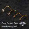 Gold-toned cubic zirconia gem nose piercing stud with a curved barbell and a separate gemstone shown on black fabric.