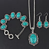 Silver vintage turquoise stone jewelry set including a necklace, earrings, and bracelet