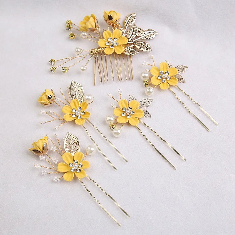 A set of five gold floral pearl bridal hair accessories featuring yellow flowers and delicate leaves.