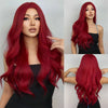 A woman models a long, vibrant red wine colored synthetic wig with curly hair.