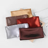 Colección de pañuelos de seda satinada doblados en tonos beige, rojo óxido, plata y marrón oscuro.