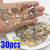 Eine Hand hält verschiedene silberne und goldene tibetische Anhänger für DIY-Schmuck.