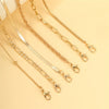 Ein Set zierlicher goldener geometrischer Fußkettchen für Damen auf hellem Hintergrund.