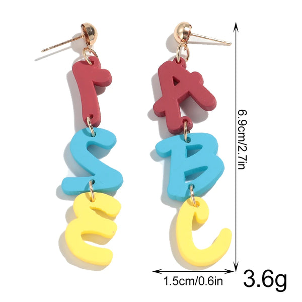 Pair of drop earrings shaped like the letters S and B in pink, blue, and yellow.