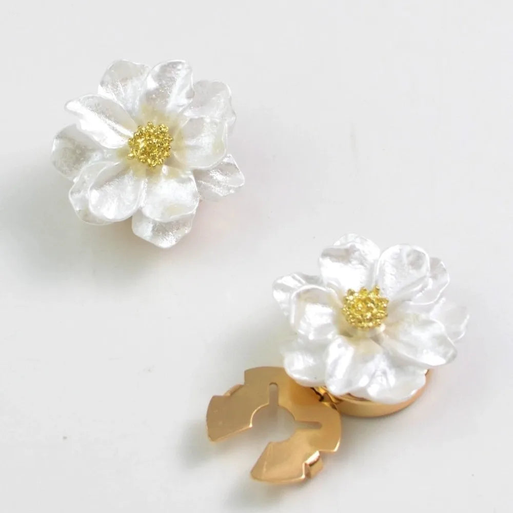 A white flower button cover with a gold center and a gold leaf shape is shown on a white background.