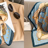 A floral print silk scarf in blue and gold tones is displayed next to a blazer.