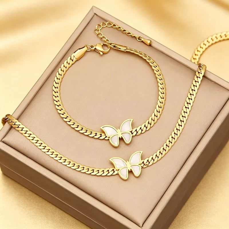 Goldfarbenes Edelstahl-Schmetterlings-Anhänger- und Armbandset in einer rechteckigen Box.