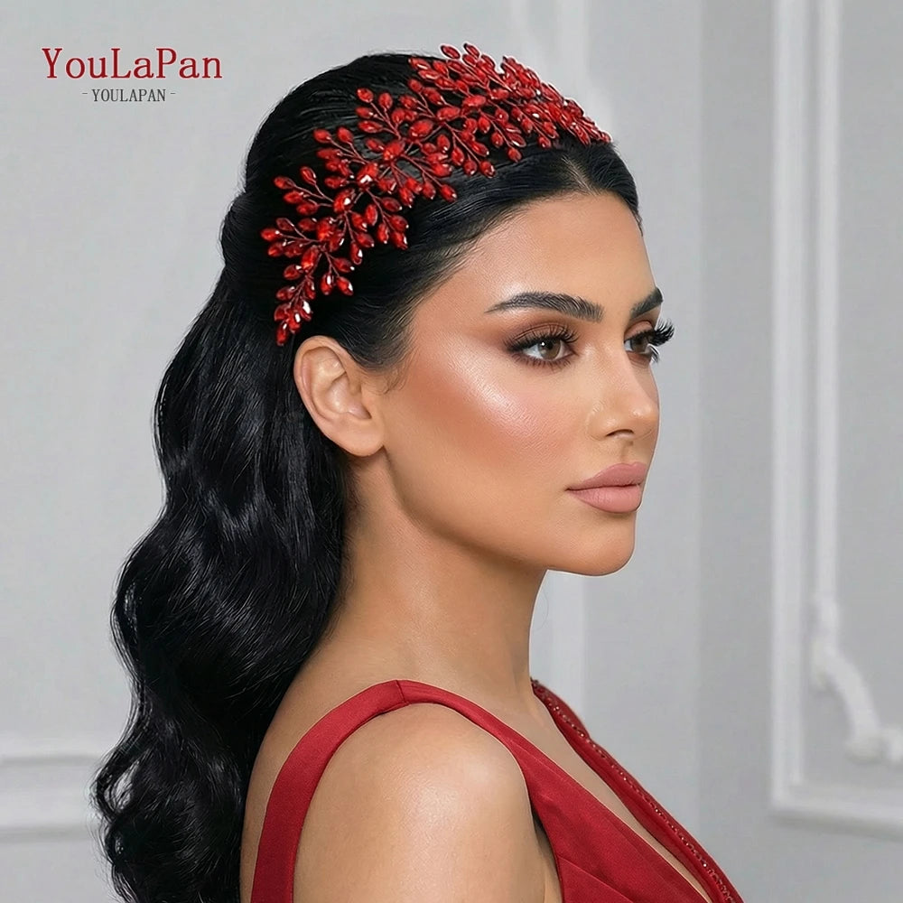A woman models a red rhinestone bridal headband worn in her dark hair and makeup.