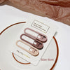 A set of three vintage frosted geometry hair clips in a dusty rose color displayed on a white card.