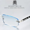 A pair of clear, frameless reading glasses with silver and black accents resting on a white surface.