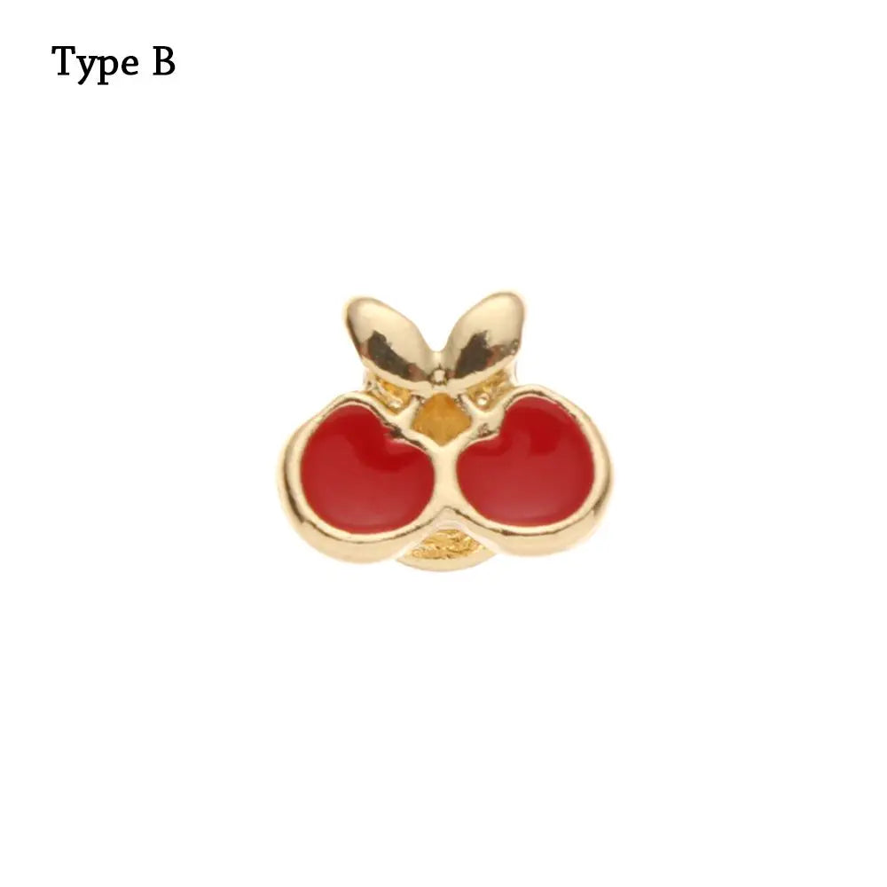 Pulsera de reloj decorativa de metal tono dorado con forma de flor estilizada y acentos rojos.