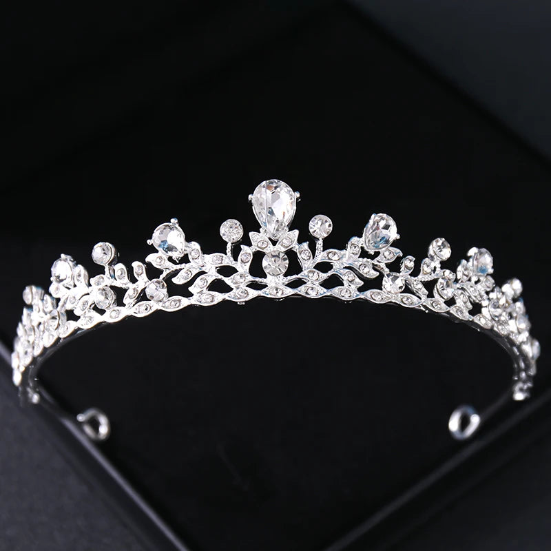 Tiara et couronne en strass de cristal, accessoire de cheveux, sur une surface sombre.