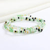 Una pulsera hecha de pequeñas cuentas verdes y amarillas con detalles negros.
