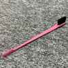 Pinkes professionelles zweischneidiges Augenbrauenkamm mit schwarter Bürste auf grauer strukturierter Oberfläche.