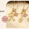 Gold letter pendant necklaces featuring initial letters and pink gemstones displayed on a natural wood background.