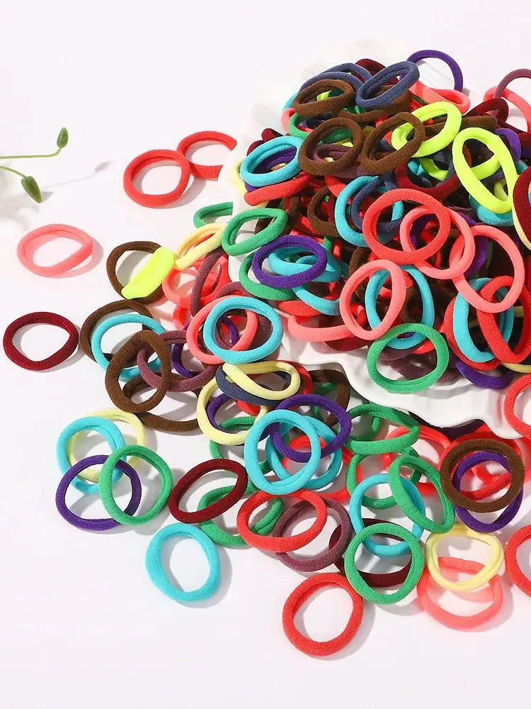 Große Packung bunter elastischer Haarbänder in verschiedenen Farben wie rot, grün, blau und lila.