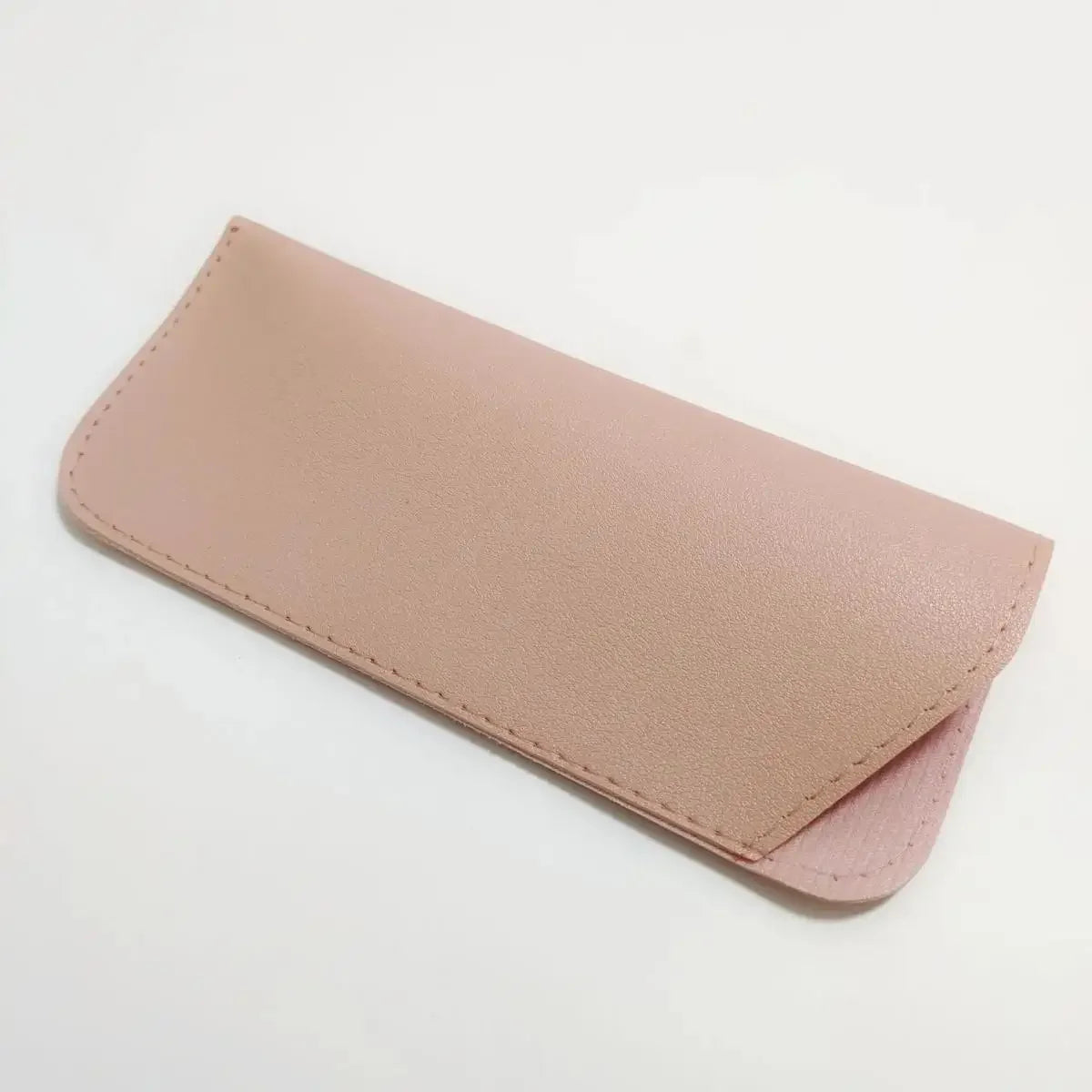 A light pink PU leather glasses case is shown lying flat on a white background.