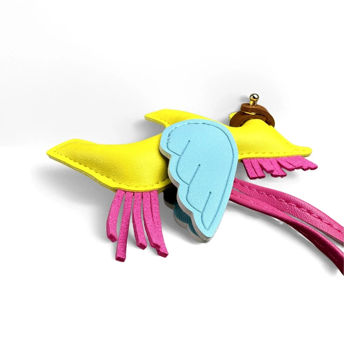 A yellow and blue winged pony keychain featuring pink fringe details.