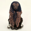 A dark blue floral embroidered lace bandana headscarf tied around dark hair.