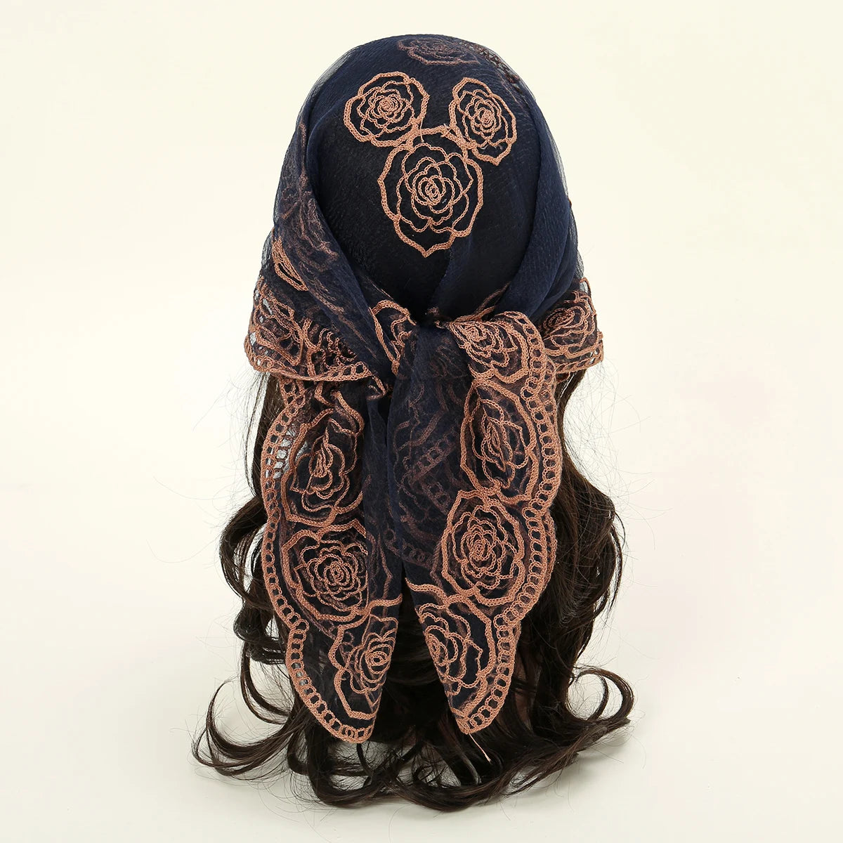 A dark blue floral embroidered lace bandana headscarf tied around dark hair.
