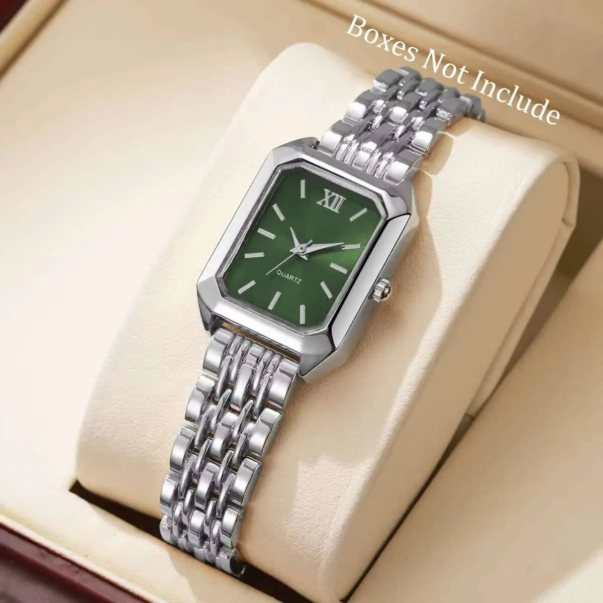 Reloj analógico de cuarzo plateado con esfera verde y pulsera de acero inoxidable, mostrado en una caja de color claro.