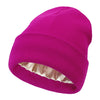 A bright magenta knitted beanie hat with a satin lining.