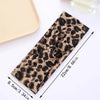A close-up view of a patterned fabric tie or bandana featuring a brown and black leopard print.