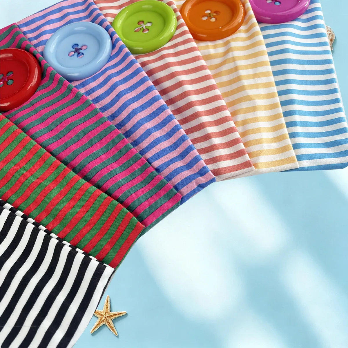 A colorful fabric headband featuring various striped and polka dot patterns in pink, green, yellow, blue, and red.