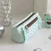 A light mint green lace pencil case with a zipper and star embellishments is displayed on a white surface.
