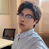 Un joven vistiendo gafas clásicas vintage anti-luz azul y una camisa de cuello azul claro.