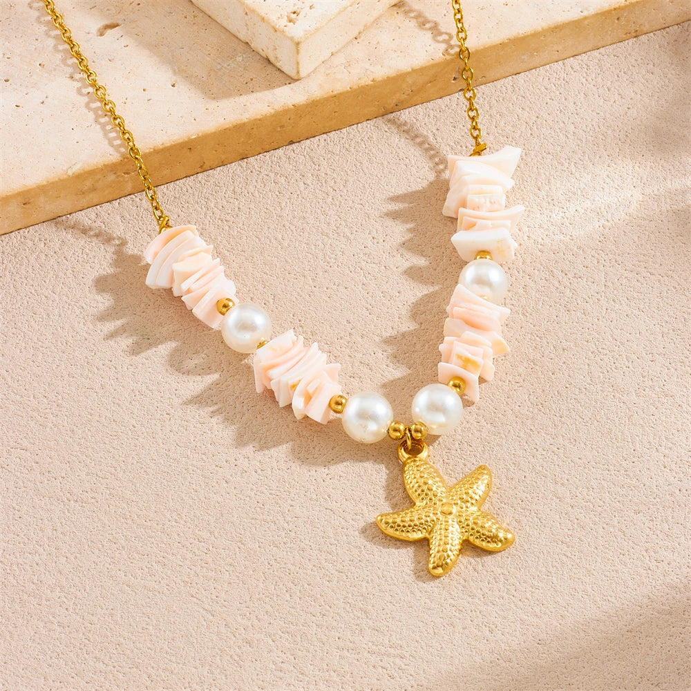 Gold chain necklace featuring pink and white floral beads and a gold starfish heart pendant