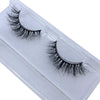 A pair of natural mink false eyelashes displayed in a clear plastic container.