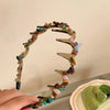 A brown resin wave toothed headband featuring various colored resin pieces.