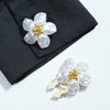 Silver baroque pearl button covers with gold accents displayed on a black fabric.