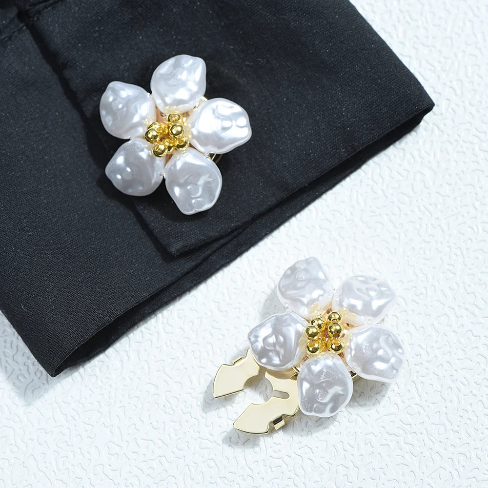 Silver baroque pearl button covers with gold accents displayed on a black fabric.