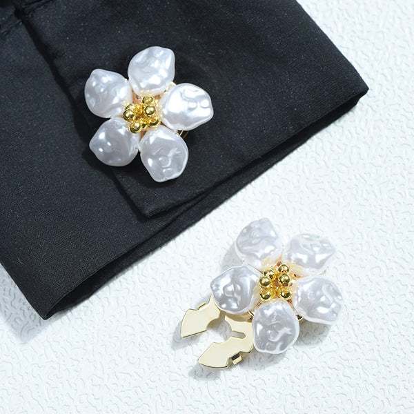 Silver baroque pearl button covers with gold accents displayed on a black fabric.
