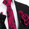 Nahaufnahme einer eleganten Herrenkrawatte mit rosa-schwarzem Paisley-Muster, schwarzem Sakko und weißem Hemd.