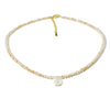 A delicate necklace featuring mother of pearl beads and crystal accents with a letter initial charm.