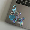 A teal resin animal dog keychain with a heart shape and a silver clasp resting on a laptop keyboard.