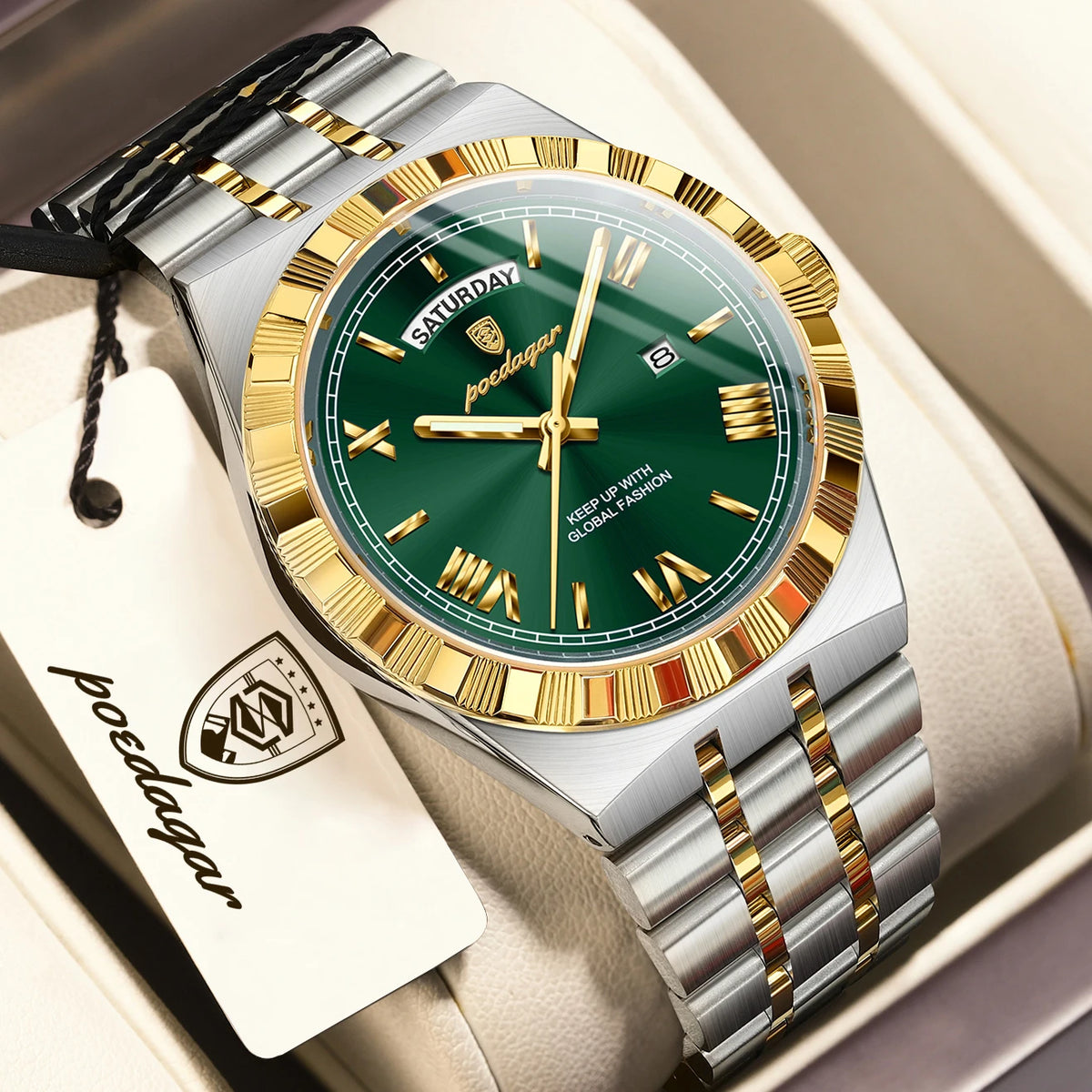 A silver and gold watch with a green dial and black strap is displayed in a box.