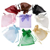 A collection of elegant organza drawstring gift bags in various colors including red, brown, purple, black, white, blue, and 