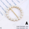 A gold-toned bracelet made of small white pearls with a thin gold chain and a decorative clasp.