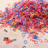 A pile of colorful disposable rubber hair ties in various shades of pink, red, blue, and yellow.