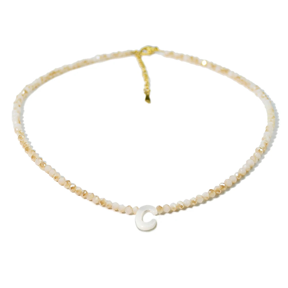 A delicate mother of pearl necklace with crystal accents and a charm.