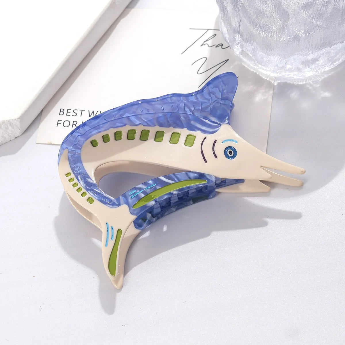 Pinza para el pelo de madera clara con forma de pez azul y acentos verdes