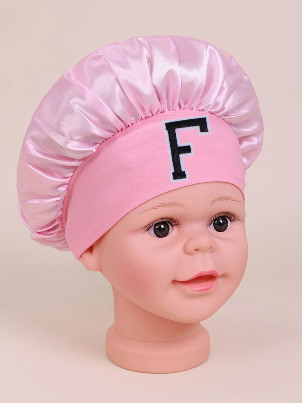 Pink A-Z letter sleep cap for kids with a black letter F