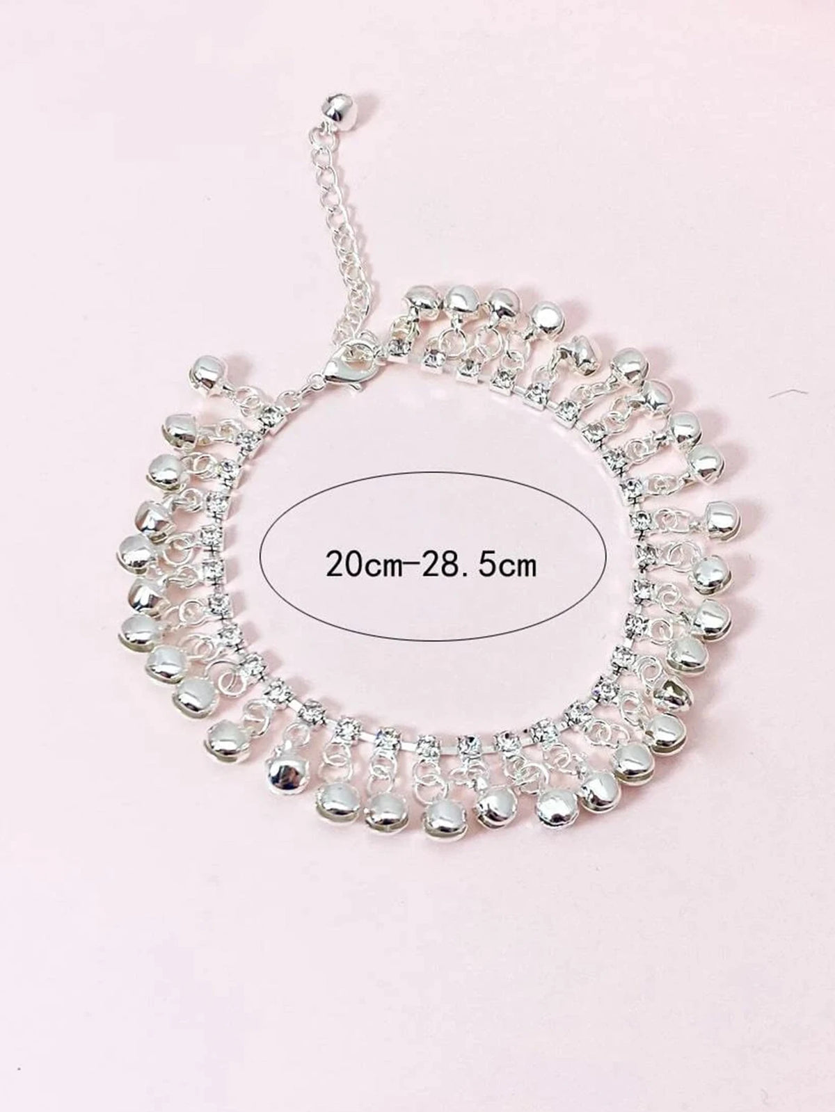 Silver bell foot chain anklet with a circular design and adjustable length markings.